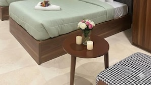 A hotel room with two beds, a small round table with candles, and a wooden headboard. - The Nomad Pyramids Boutique Hotel (Giza)