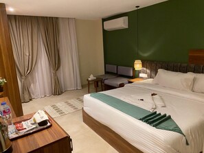 Una habitación de hotel con una cama, un escritorio, una silla, una lámpara y una ventana con cortinas.