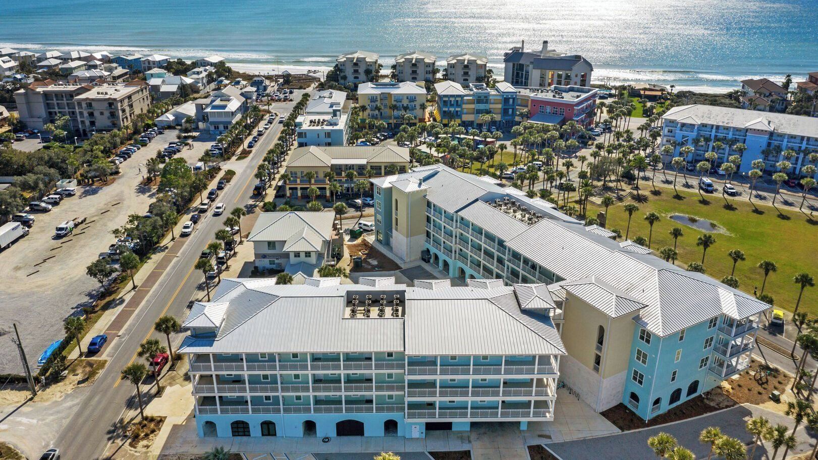 Ein Hotel an der Küste mit Innenhof, mehreren Etagen und Blick auf den Strand.