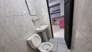Ein Badezimmer mit Toilette, Waschbecken und Spiegel.