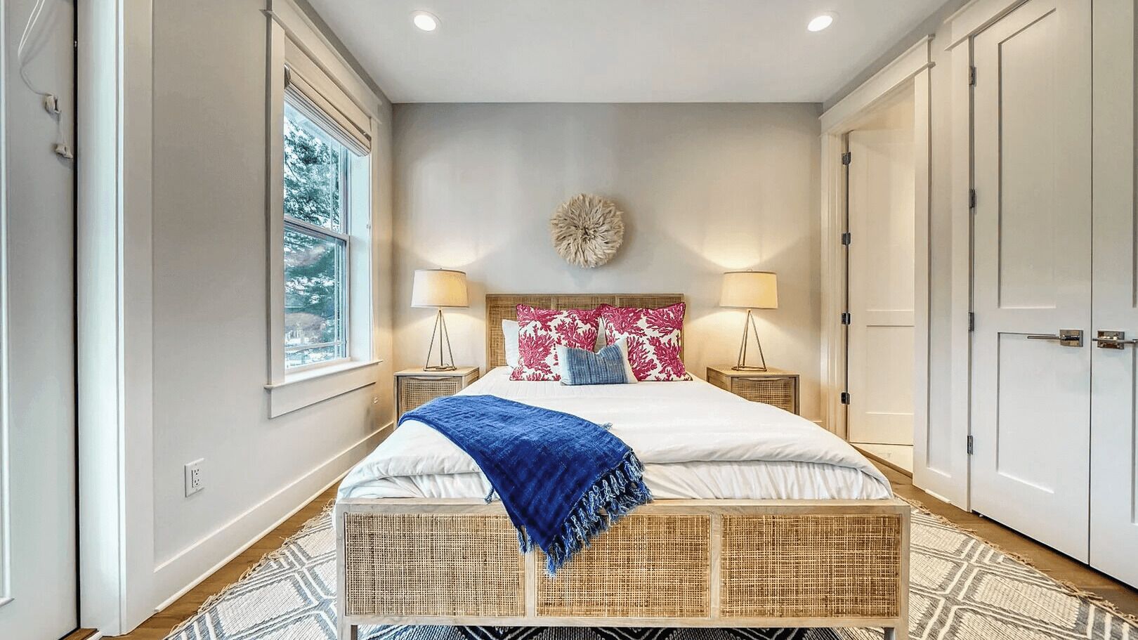 Un dormitorio con cama, mesitas de noche, un elemento decorativo en la pared y un armario.