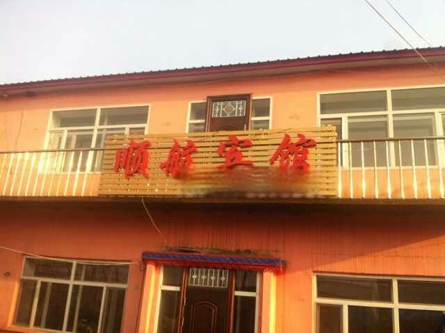 A building with a sign that reads 'Hotel' in red characters.