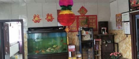 A room with a large fish tank, a reception desk, and various decorations.