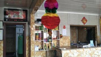 A hotel reception area with a marble counter, shelves with various items, and a green fire extinguisher.