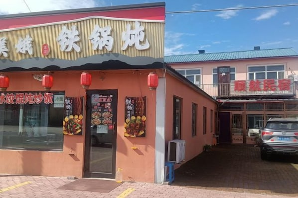 Un edificio con fachada comercial y zona de estacionamiento.