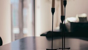 Una mesa con tres velas sobre pedestales.