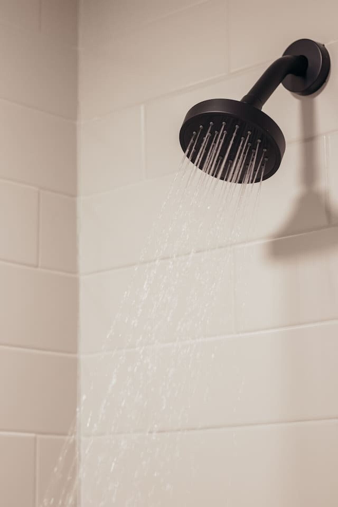 Een douchekop waar water uit stroomt.