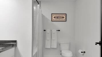 Une petite salle de bain comprenant des toilettes, un porte-serviettes et une pancarte indiquant « SALLE DE BAIN » sur le mur.