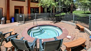 An outdoor swimming pool with a circular design, surrounded by a brick patio.