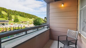 A balcony with a view of a green landscape and a building labeled "The Condorla."