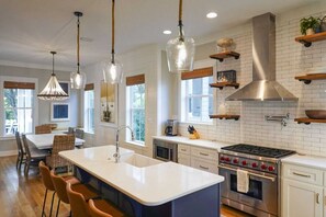 A modern kitchen with a central island, stainless steel appliances, and pendant lighting. - Bella Sol by Avantstay Resort Pool, Private Beach Access, Bikes (Panama City Beach)