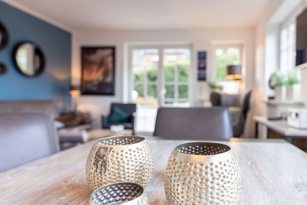 A dining area with a wooden table and three perforated candle holders.