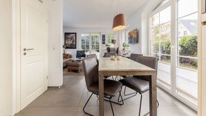 Een moderne keuken met een eetgedeelte, grote ramen en uitzicht op de omgeving.