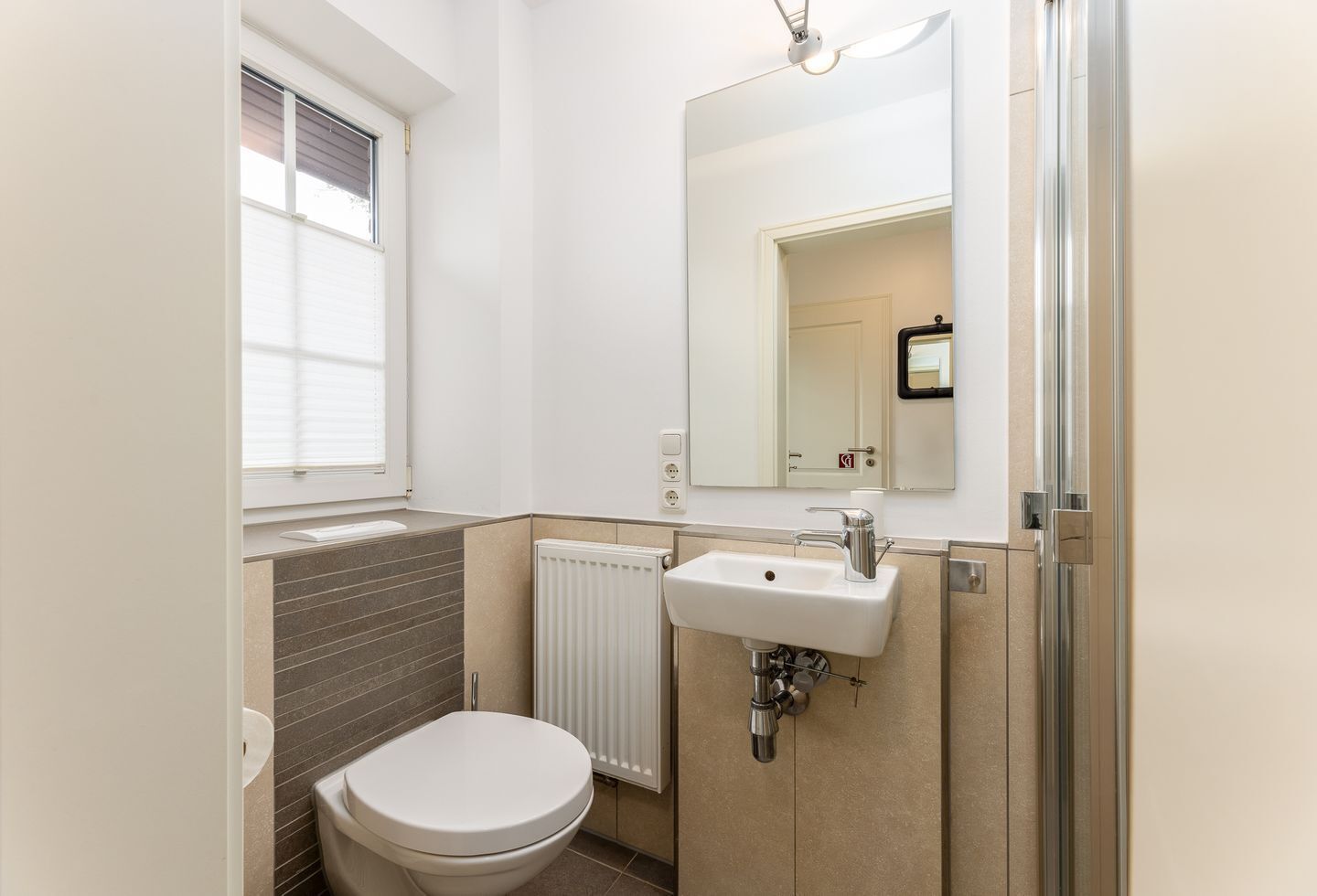 Une salle de bain moderne avec des toilettes, un lavabo et un miroir.