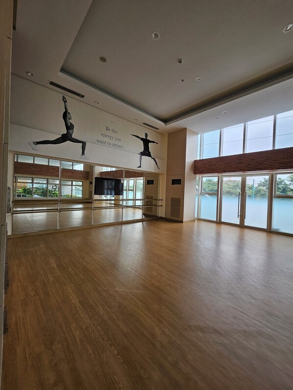 A spacious dance studio with wooden floors, large windows, and motivational wall art. - Luxury condo with gym,WiFi,NETFLIX at Park Mckinley West, Venice, SM Aura BGC (Taguig)