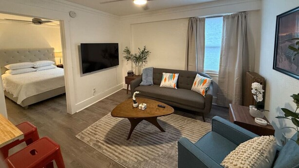 Una camera d'albergo moderna con un letto, un divano, un tavolino da caffè e una TV.
