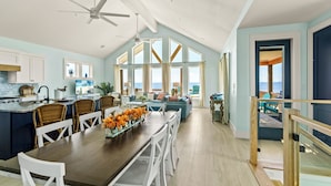 A spacious kitchen with a dining area, large windows, and a view of the ocean. - Luxurious Beachfront 4BR with Pool, Hot tub, Elevator (Port Bolivar)