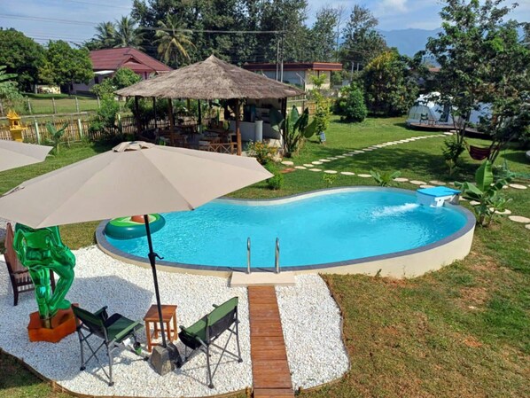 Patio con piscina, tobogán y mobiliario exterior.