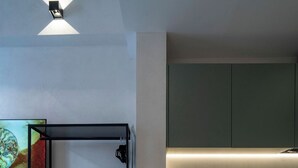 A compact living space with a bunk bed, a kitchenette, and a dining area.