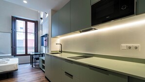 A modern kitchen with a built-in microwave, a sink, and a dining area with a table and chairs.