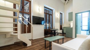 Una sala de estar moderna con una escalera, un comedor y una cocina.