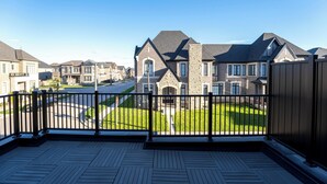 Un quartier résidentiel doté d’une terrasse en bois et offrant une vue sur des maisons aux façades en pierre et aux toits à deux versants.