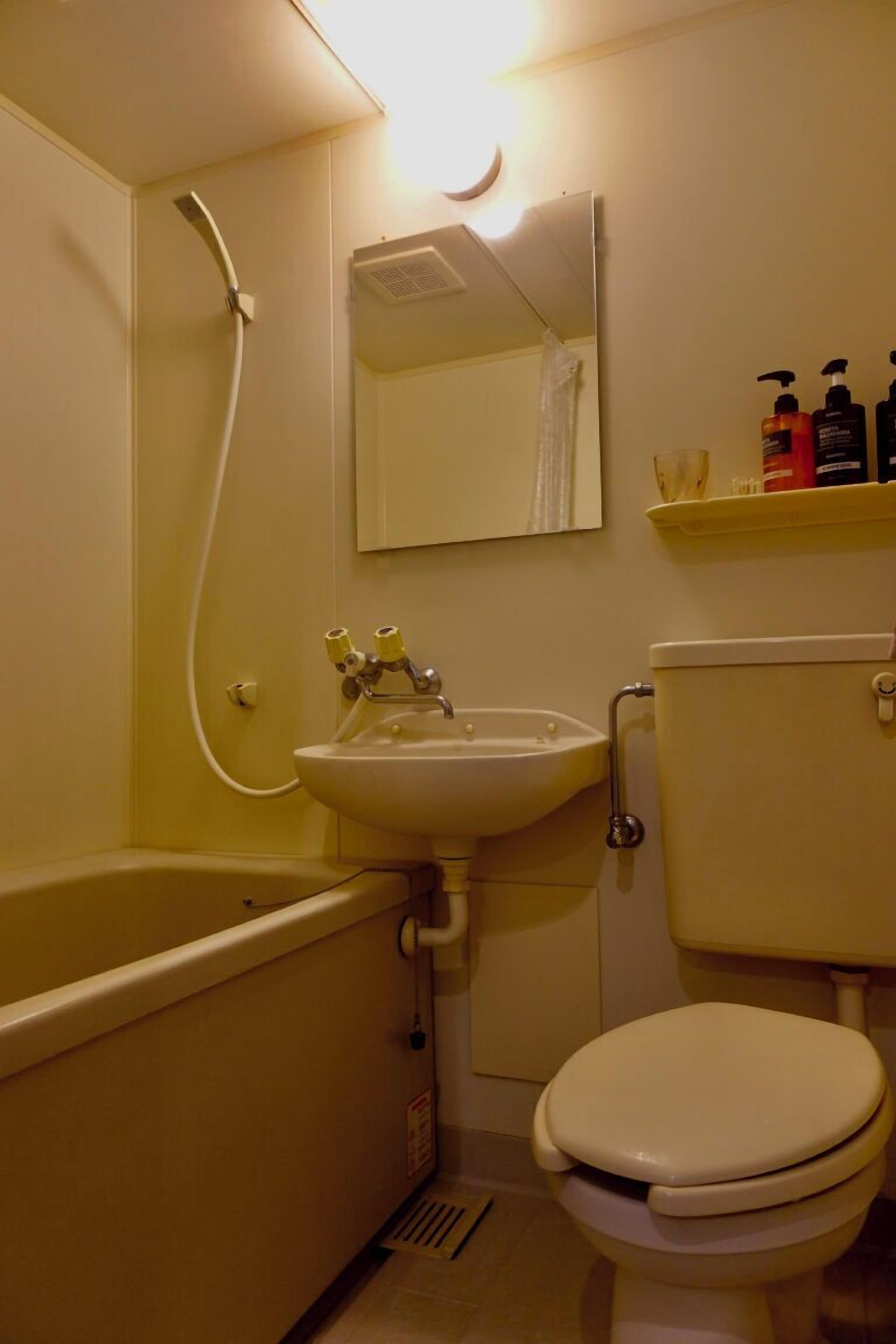 Une salle de bain équipée d’une baignoire, d’un lavabo, de toilettes et d’un miroir au-dessus du lavabo.