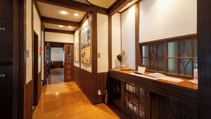 A hallway with wooden paneling, a reception desk, and a fire extinguisher. - Cottage Alice (Hachimantai)