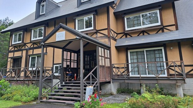 A two-story building with a gabled roof, a covered entrance with steps, and a sign that reads "ALICE". - Cottage Alice (Hachimantai)