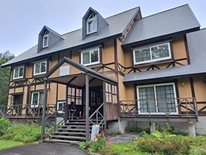 A two-story building with a gabled roof, a covered entrance with steps, and a sign that reads "ALICE".