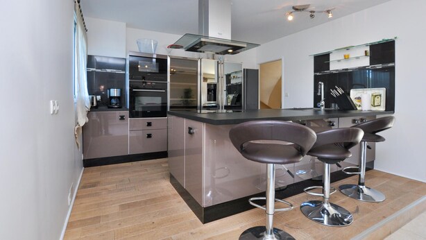 A modern kitchen with a central island, stainless steel appliances, and bar stools. - Beautiful home in Sainte Maxime (Sainte Maxime)