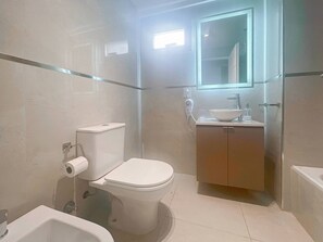 A modern bathroom with a toilet, bidet, and a glass-enclosed sink. - Luxury In Best Area San Telmo (Buenos Aires)