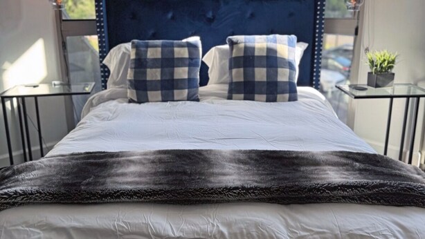 A neatly made bed with a checkered pillow, a dark headboard, and a neon sign that reads "IT WAS ALL A DREAM". - Downtown LA - Free Parking- Legends Loft! (Vernon)