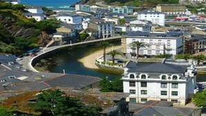 A coastal town with a prominent white building, a curved road, and a lighthouse in the background. - Room-cozy Double Room With Private Bathr (Valdes)