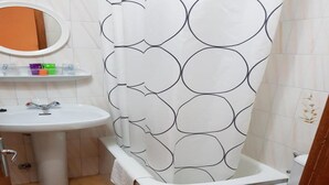 A bathroom with a white sink, a mirror, a toilet, and a shower curtain with a circular pattern. - Room-cozy Double Room With Private Bathr (Valdes)