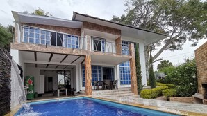 Una casa de dos pisos con piscina en el patio delantero.