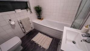 Une salle de bain moderne avec une baignoire, des toilettes et un lavabo.