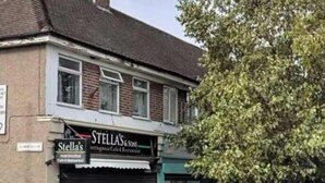 Un immeuble dont le rez-de-chaussée affiche une enseigne indiquant « Stella's Cafe & Restaurant ».