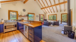 Una cocina amplia con vigas de madera, una isla grande y un horno empotrado.
