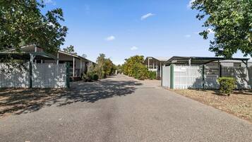 Stroll down a serene tree-lined street to a charming home with a small porch and fenced yard.