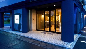 A hotel entrance with a glass door, a signboard, and a paved walkway. - Hotel Areaone Naruto (Naruto)
