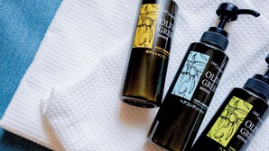 Three bottles of hair care products with pump dispensers, placed on a white towel over a blue and white checkered surface. - Hotel Areaone Naruto (Naruto)