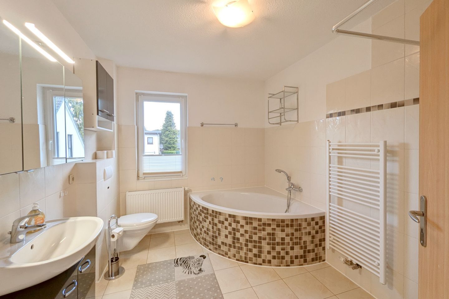 Une salle de bain moderne équipée d’une baignoire, de toilettes et d’un lavabo.
