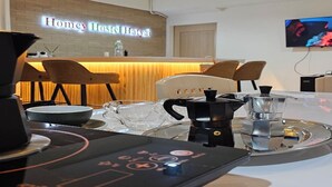 A modern kitchen area with a coffee machine, a kettle, and a tray with a teapot and cups. - Homey Hostel Hatyai (Hat Yai)