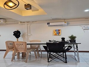A dining area with a table, chairs, and a ceiling light fixture.