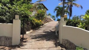 A pathway leading to a building surrounded by lush greenery and palm trees. - Bella Vista, Las Terrenas (Las Terrenas)