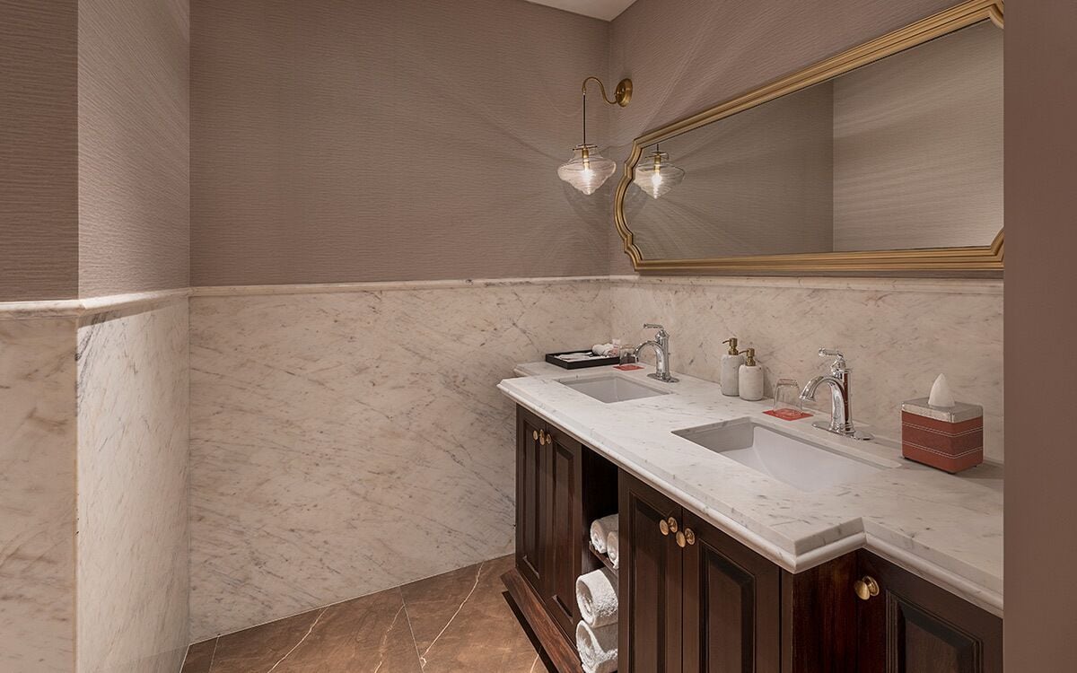Een badkamer met twee wastafels, een grote spiegel en een handdoekhouder.