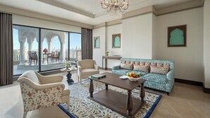 Un salón amplio con sofá, sillones, una mesa de centro y un balcón con vistas.
