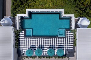 An aerial view of a rooftop swimming pool with a checkered floor, surrounded by lounge chairs and umbrellas. - Welcomhotel By ITC Hotels Jabalpur (Jabalpur)