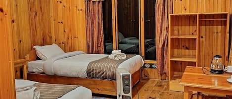 A wooden room with a bed, a table with a kettle and cups, and a wardrobe.